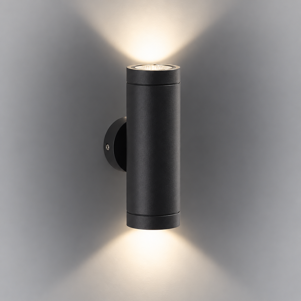 Outdoor wall light black 6302bk, sleek cylindrical design illuminating with warm light on a textured wall.