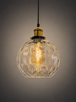 A hanging pendant light with a clear textured glass globe shade