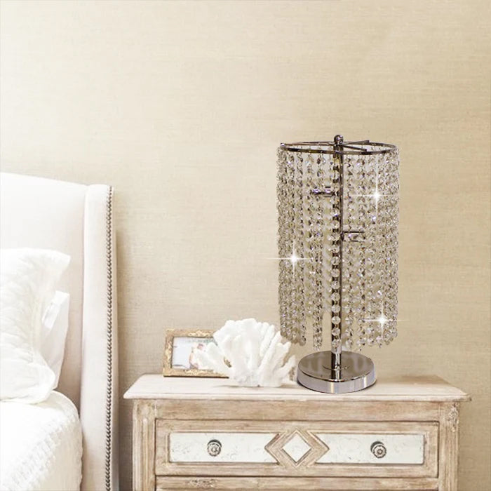Decorative table lamp with crystal accents on a nightstand next to a bed nz