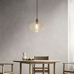 Pendant light hanging above a dining table with chairs in a minimalistic room NZ
