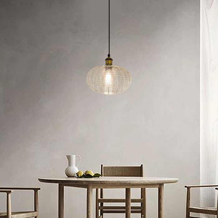 Pendant light hanging above a dining table with chairs in a minimalistic room NZ