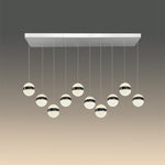 A modern LED pendant light with chrome finish and multiple round lamps hanging from a central bar nz
