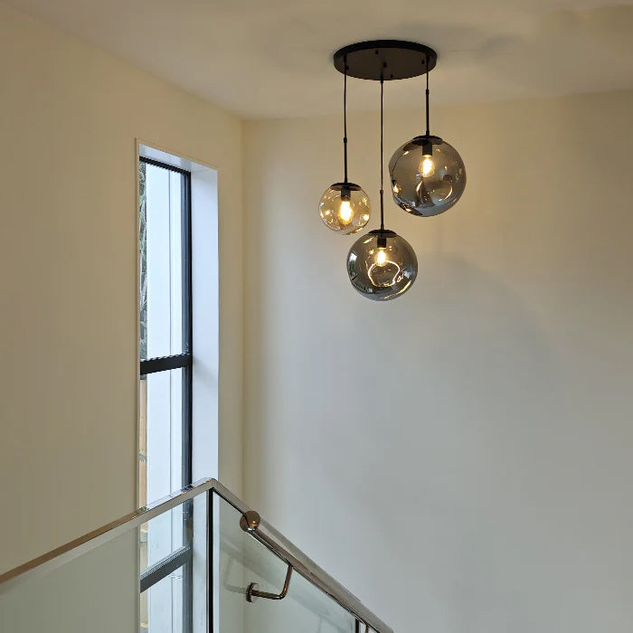 Modern ceiling light fixture with glass shades in a home interior.