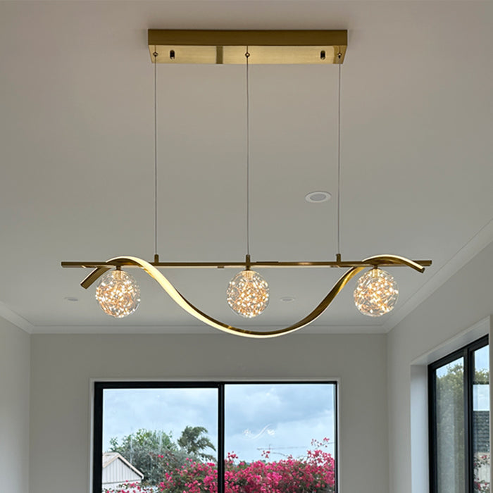 Modern island light fixture with gold finish and glass shades inthe kitchen west auckland