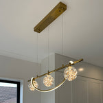 Modern island light fixture with gold finish and crystal-like glass shades in a room setting nz