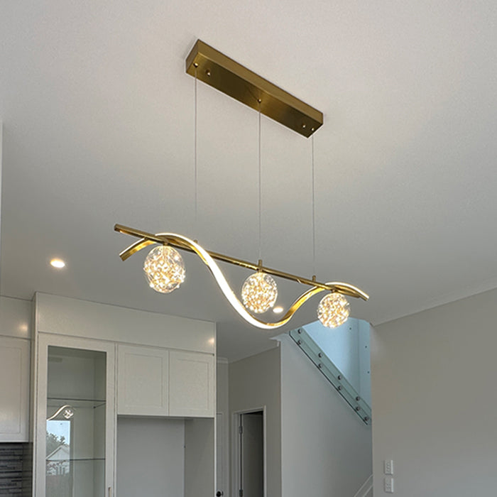 Modern kitchen light fixture with three illuminated bulbs in a home interior nz