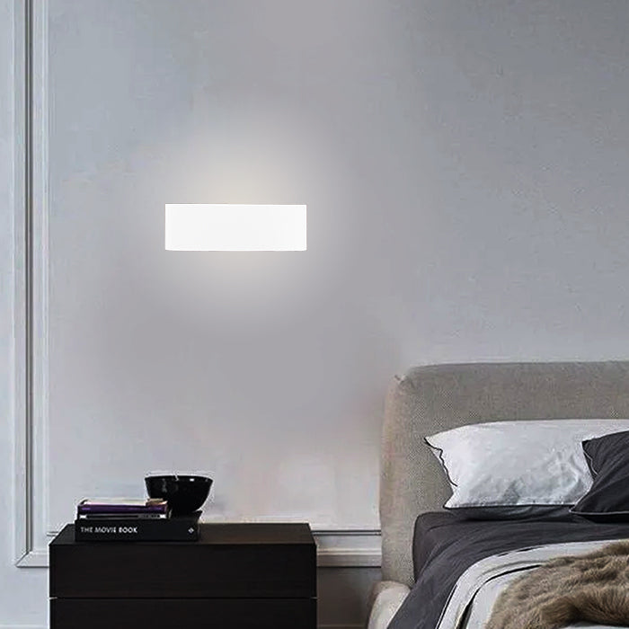 Modern wall light fixture on a gray wall above a bed with a nightstand nz