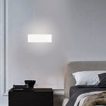 Modern wall light fixture on a gray wall above a bed with a nightstand nz