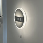 Round wall light fixture with pull chain on a gray wall auckland