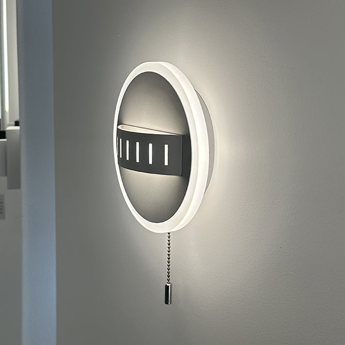 Round wall light fixture with pull chain on a gray wall auckland