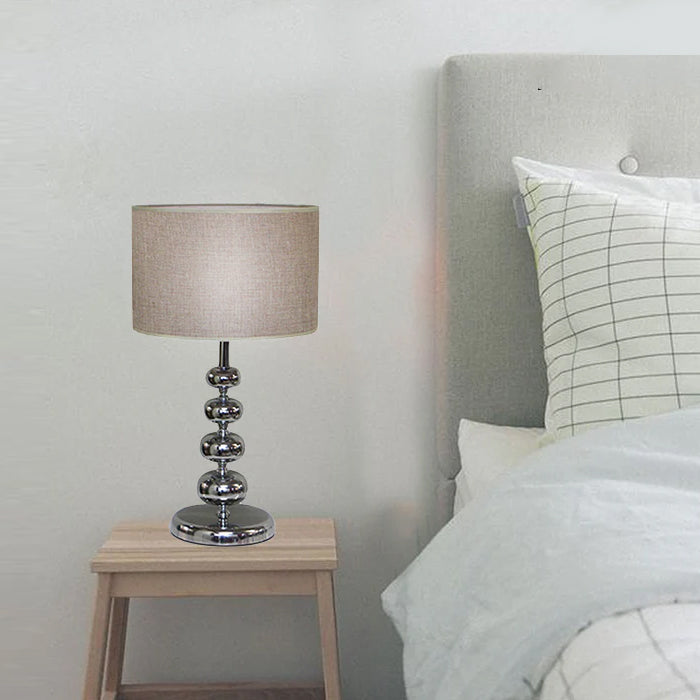 Table lamp on a nightstand next to a bed nz