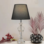 Table lamp with black shade and clear glass base on a white surface nz
