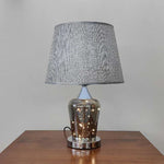 Table lamp with textured gray shade and metallic base on a wooden surface nz