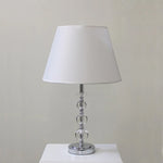 Table lamp with a white shade and crystal base on a white surface west auckland