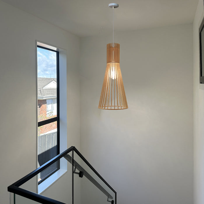 Wooden pendant light hanging in a room with a window and staircase nz
