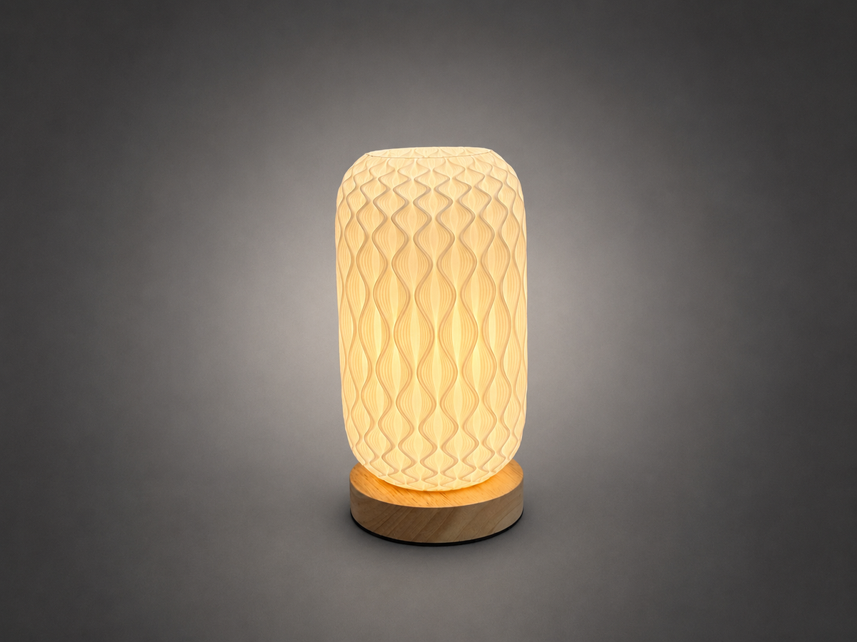 A modern table lamp with a textured, honeycomb-patterned cream-colored shade and a round natural wood base, glowing with a warm light against a dark gray gradient background.