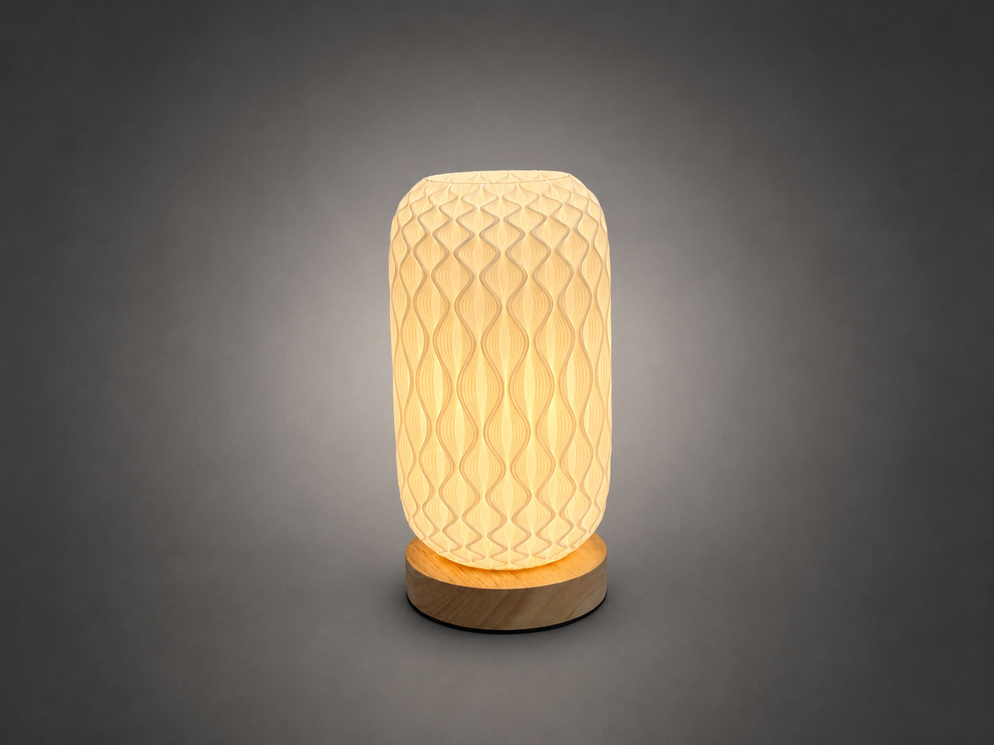 A modern table lamp with a textured, honeycomb-patterned cream-colored shade and a round natural wood base, glowing with a warm light against a dark gray gradient background.