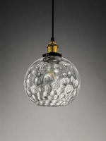 A clear textured glass pendant light with a hammered bubble pattern, suspended from a black cord with a gold metal cap, set against a dark gray gradient background.