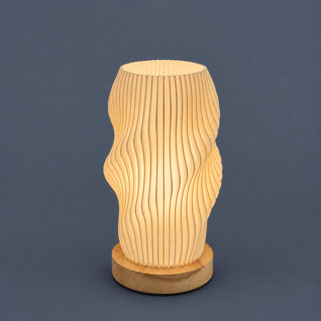 A modern wavy table lamp made of laser-cut wood, glowing with a warm light, set against a solid dark gray background.